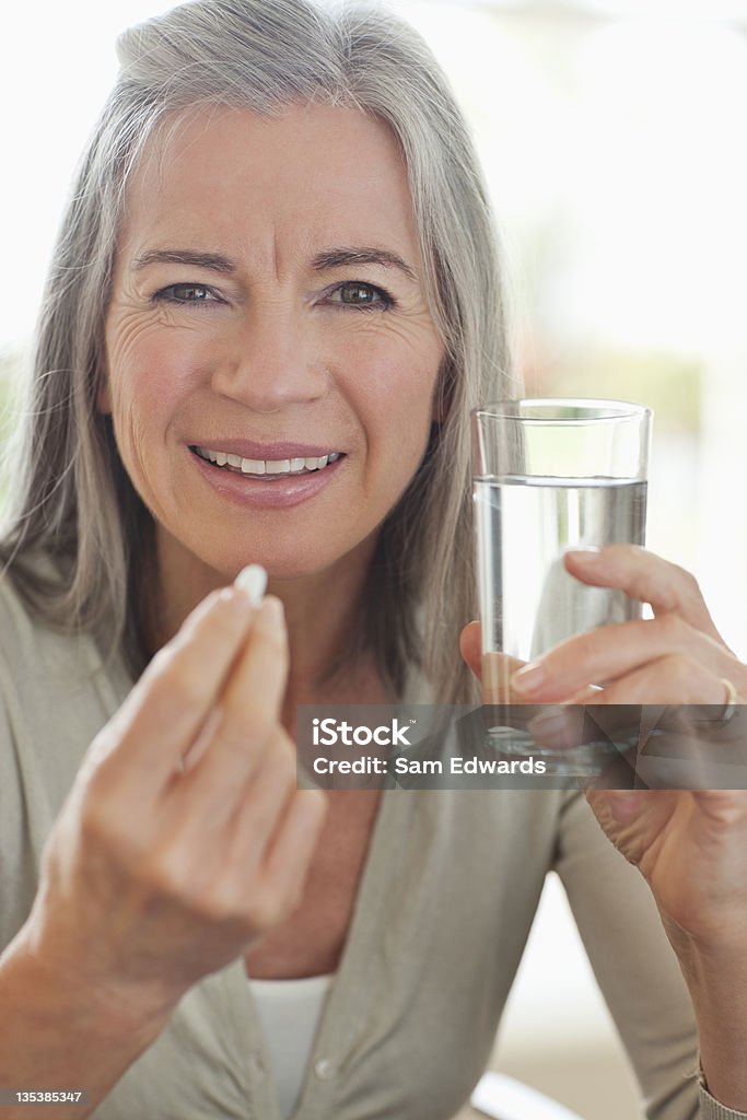 水の持つ女性ながらの錠剤 - 中年の女性のロイヤリティフリーストックフォト