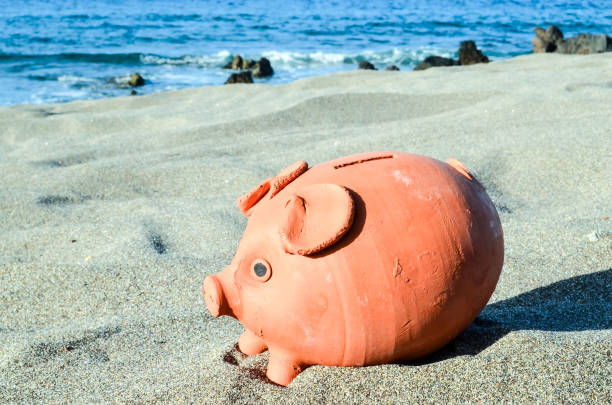 istock Piggy Bank on the Sand Beach 1353854699