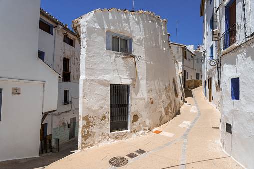 Chelva, Spain - June 27, 2021: White and blue houses in the streets of the mudejar neighborhood of Arrabal in the beautiful village of Chelva in a sunny day, Valencia, Spain
