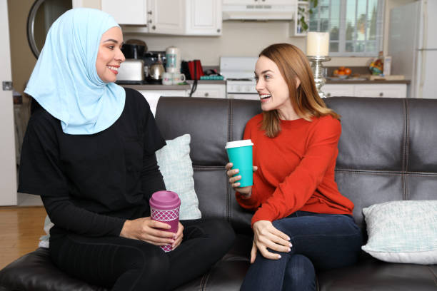 istock Reusable Coffee Cup Friends Talk on Couch 1353858481