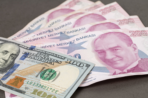 Dólares estadounidenses y liras turcas uno encima del otro cubriendo completamente la pantalla. 1 dólar estadounidense es igual a 10 liras turcas concepto de sesión de fotos photo