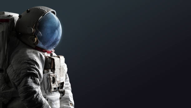 istock Astronaut isolated on dark background. Spaceman with space and stars in helmet. Creative sci-fi digital and space wallpaper 1353863639