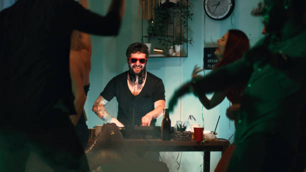 istock Male DJ working during home party 1353864262