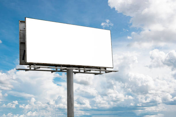istock Empty Blank  billboard mockup with white screen against cloudy sky background. 1353864515