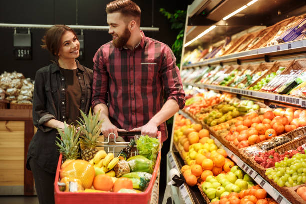 istock Happy loving couple in supermarket 1353864821