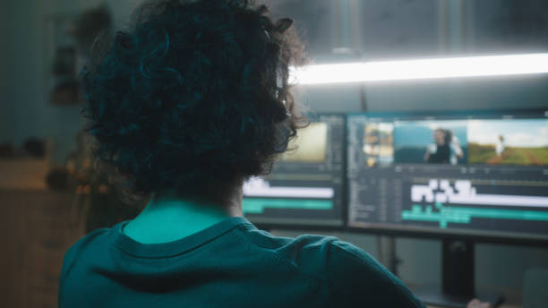 istock Man in headphones editing video late at night 1353867064