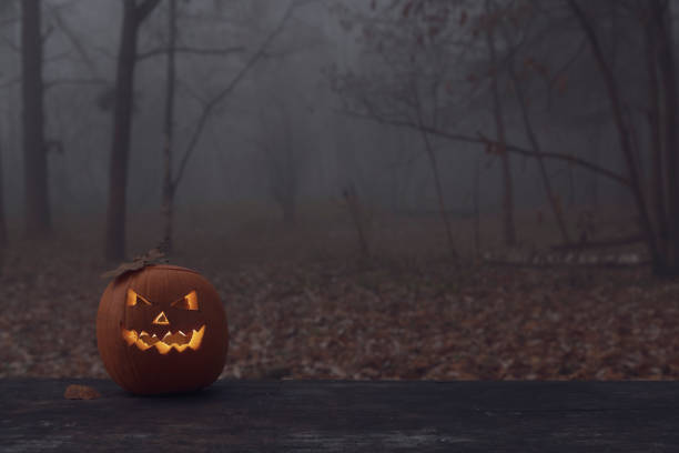 istock Halloween pumpkin lies on table in dark forest 1353871227