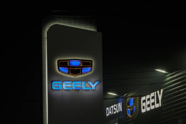 logo geely sul pilastro della concessionaria auto e sull'edificio nella notte nebbiosa - geely è uno dei più grandi produttori di automobili cinesi - branding marketing sign brand name foto e immagini stock