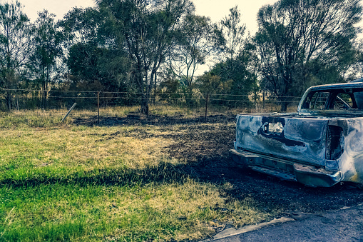 A burned car on the side of the road in Australia.
