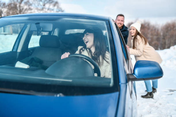 istock Female Getting Help From Friends With Car Stuck In Snow 1353874224