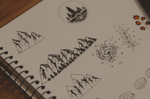 random doodles draws with black pencil on a notebook