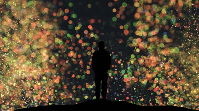 The human silhouette standing on a magic flying particles background