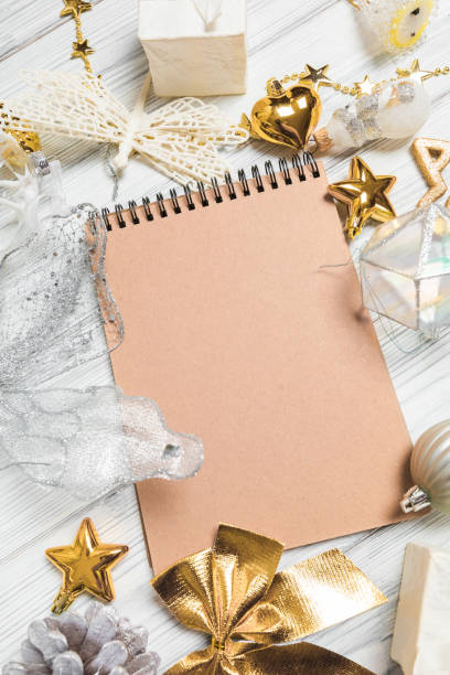 istock golden christmas decorations and notebook on white background. Flat lay, top view, copy space 1353879249
