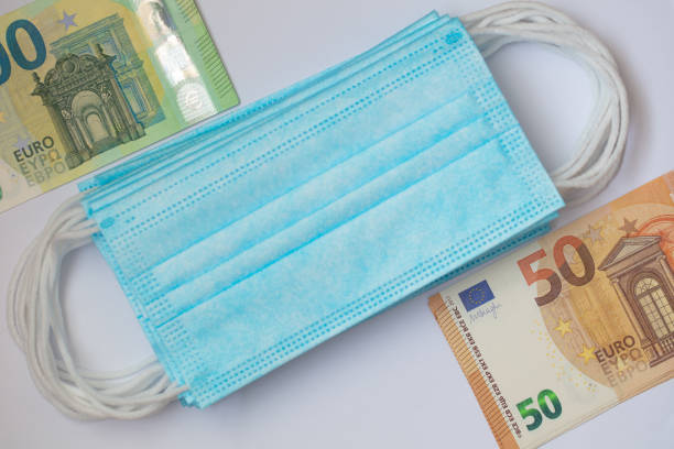 istock surgical masks and 50, 100 euro banknotes 1353881453