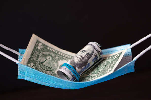 istock surgical mask as hammock with 1 and 100 dollar banknotes 1353883184