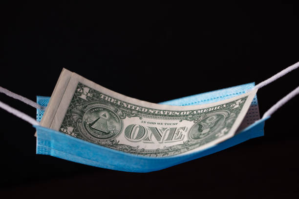 istock surgical mask as hammock with 1 dollar banknotes 1353883242