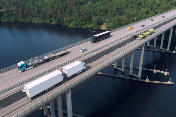 Aerial view of a highway bridge with various trucks and transports on the road.