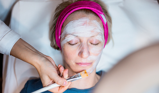 Applying foam to the face of the woman before the mesotherapy procedure