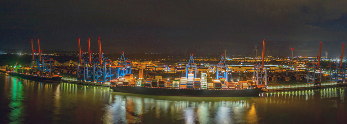 Container terminal, loading and unloading of various shipping container and the freight station in the night. A seaport on the river Elbe in Hamburg in the night.