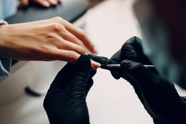 istock Manicure process female hands finger nails polish 1353899437