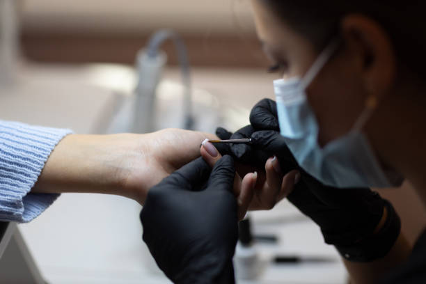 istock Manicure process female hands finger nails polish 1353899490