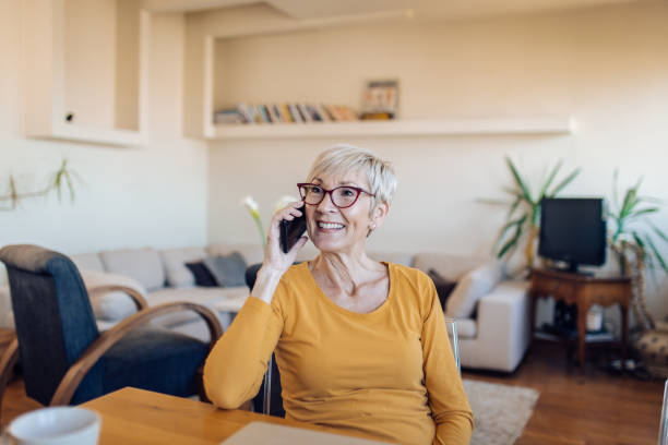 istock Senior woman talking on the phone and having fun 1353901523