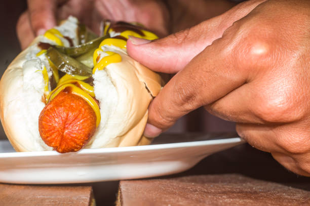 american hot dog with sausage, mustard, pickle and barbecue sauce