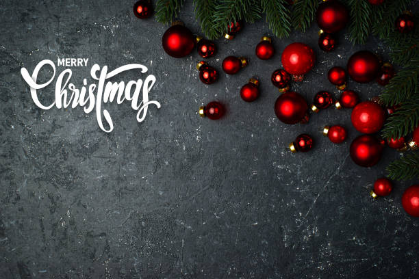 istock Red christmas balls and christmas tree on the black stone background 1353910045