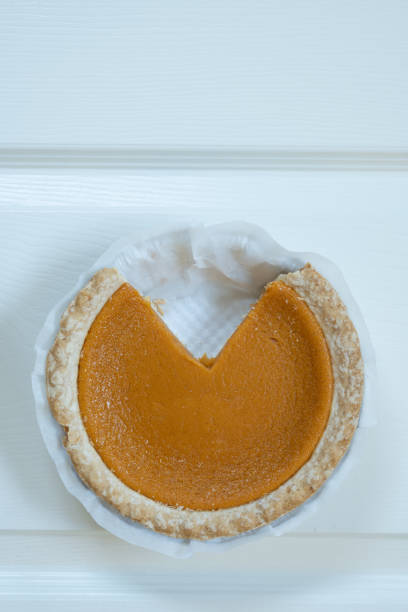 istock Vertical shot of pumpkin pie on white background 1353917261