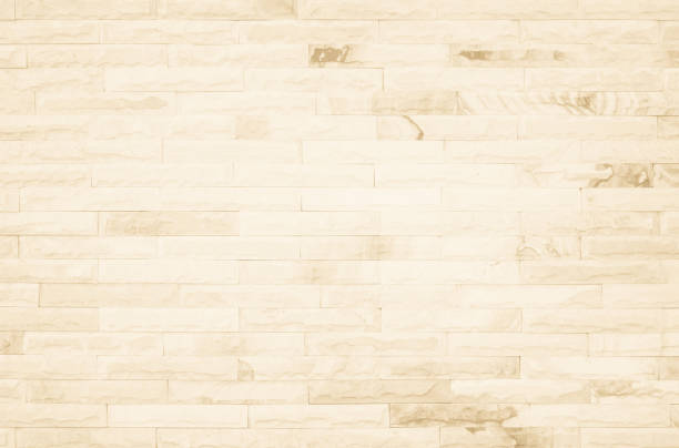istock Empty background of wide cream brick wall texture. Beige old brown brick wall concrete or stone textured, wallpaper limestone abstract flooring/Grid uneven interior rock. Home decor design backdrop. 1353917781