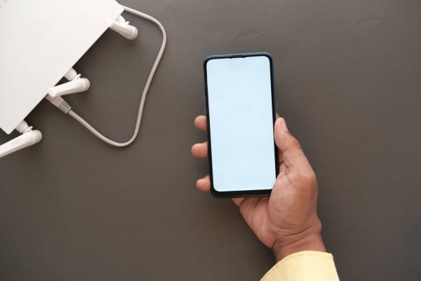 istock Wi-Fi wireless internet and hand holding smart phone on table 1353918394