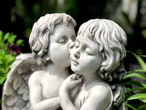 Couple cupids sculpture kissing close up. Valentine background