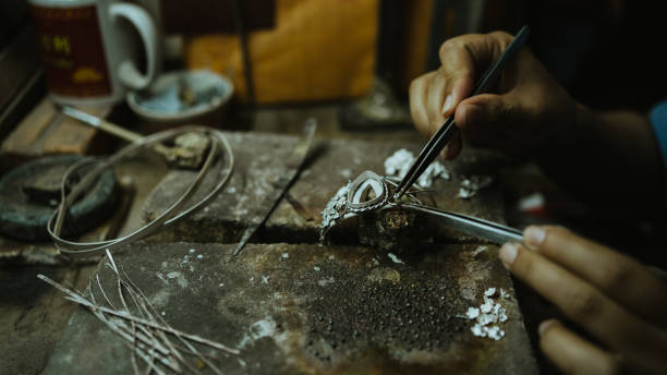 gioielliere al lavoro in gioielleria. desktop per la creazione di gioielli artigianali con strumenti professionali. vista ravvicinata degli strumenti. gioielli in argento. - jewelry craftsperson craft jeweller foto e immagini stock