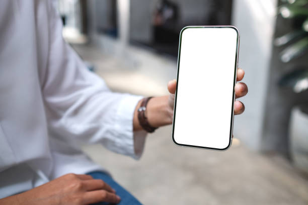 istock a woman holding and showing mobile phone with blank desktop screen 1353924565
