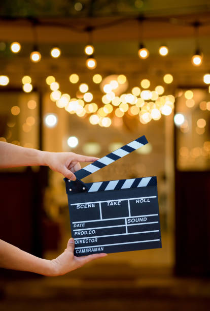 homem mãos segurando o bate-palmas do filme. conceito de diretor de cinema. câmera mostrar imagem visor pegar movimento em entrevista ou transmissão cerimônia de casamento, pegar sentimento, mão mulher segurar uma ardósia filme sobre bokeh - hollywood movie - fotografias e filmes do acervo