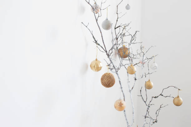 istock christmas  branches with golden and white  balls on white wall background 1353933801