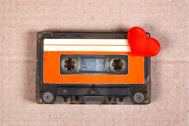 Old Audio Cassette Old Audio Cassette with a Red Heart on the Cardboard Background closeup mix tape heart stock pictures, royalty-free photos & images