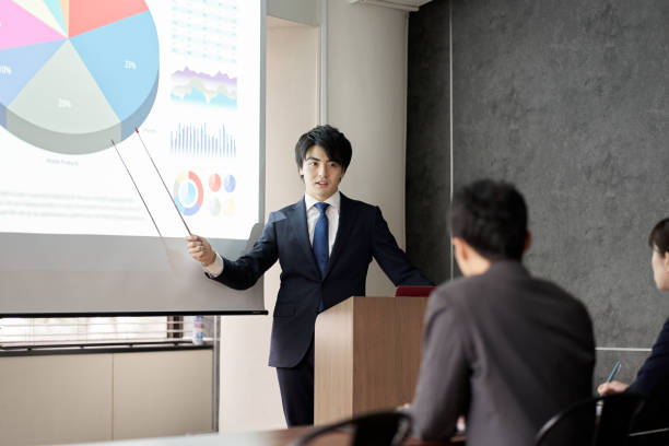 istock Asian businessman giving a presentation at a conference 1353938875