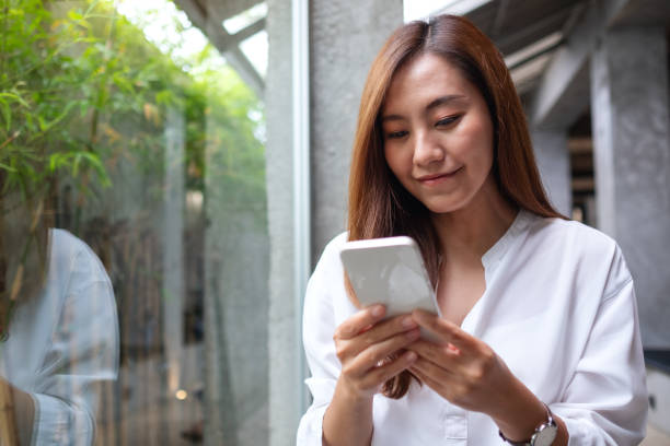 istock A beautiful young asian woman holding and using mobile phone 1353944416