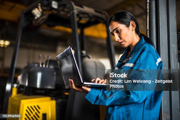 Indian Female Steel Factory Worker Using A Laptop Stock Photo - Download Image Now - Manufacturing, Engineer, Indian Ethnicity