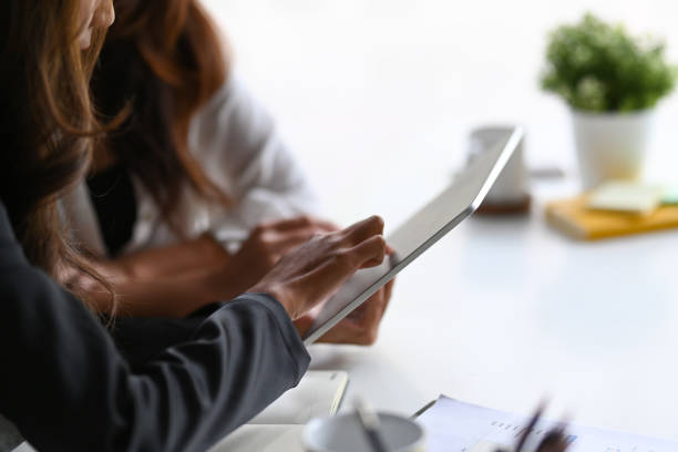 istock Two business colleagues sitting n office and analyzing financial data on digital tablet. 1353948473