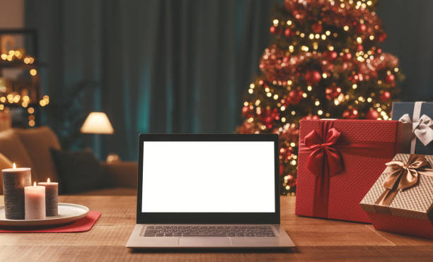 istock Laptop with blank screen, gifts and Christmas tree 1353952337