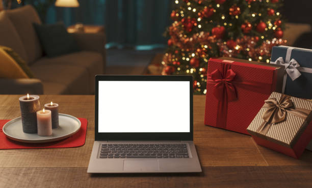 istock Laptop with blank screen, gifts and Christmas tree 1353953176