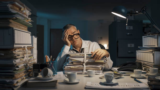 istock Exhausted businessman working overtime in the office 1353953903