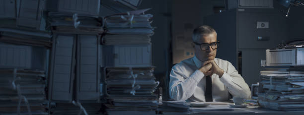 istock Pensive businessman overloaded with paperwork 1353953931