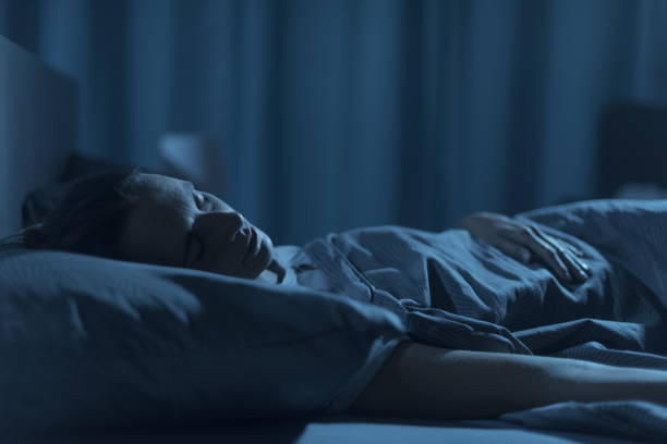 Woman sleeping in her bed at night Woman sleeping in her bed at night, healthy lifestyle concept woman sleeping in bed at night stock pictures, royalty-free photos & images