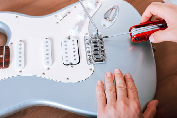 istock Guitar master adjusting bridge saddle on tremolo of electric guitar using multitool 1353961472