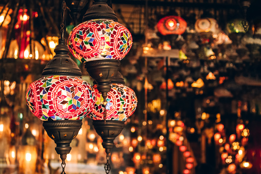 Traditional turkish or moroccan light mosaic lamp. Colorful stained glass lamp against defocused souvenir shop background with copy space. Popular souvenir and ideas for present. Selective focus