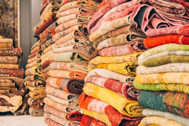 istock Stack of traditional oriental carpets and rugs as background with copy space. Multicolored ornamental carpets at carpet store. Popular touristic souvenir. Selective focus 1353962794