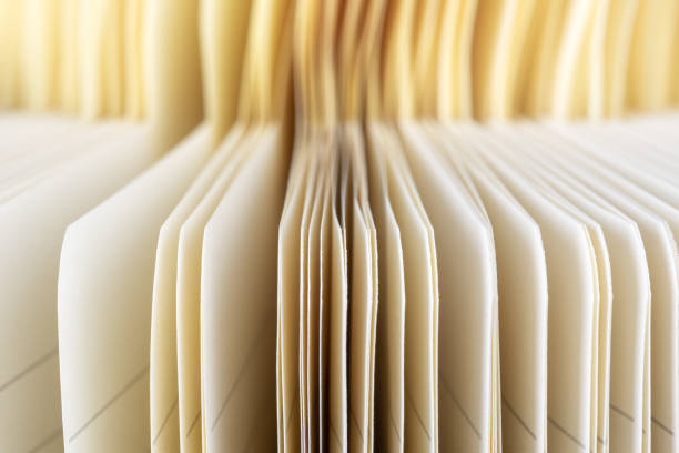 istock Edge of pages, opened blank notebook with bookmarks in blurred background 1353963475